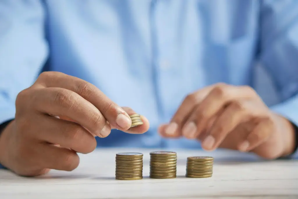 Persona organiza monedas para reorganizar sus finanzas